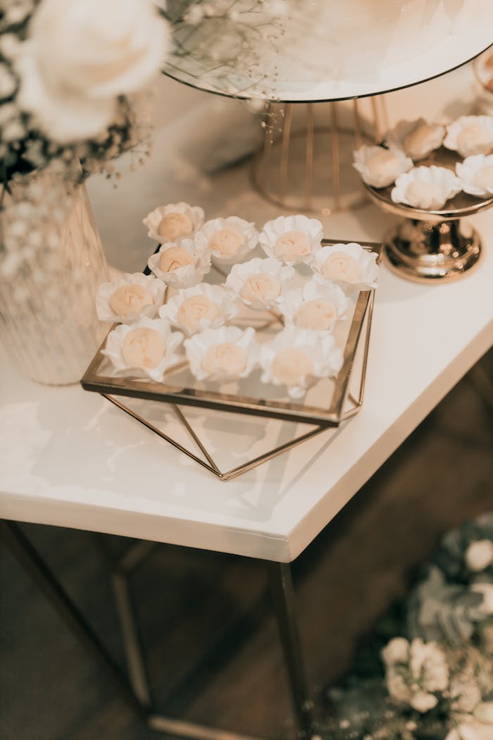 Chic wedding dessert table with white floral decor in elegant setting.